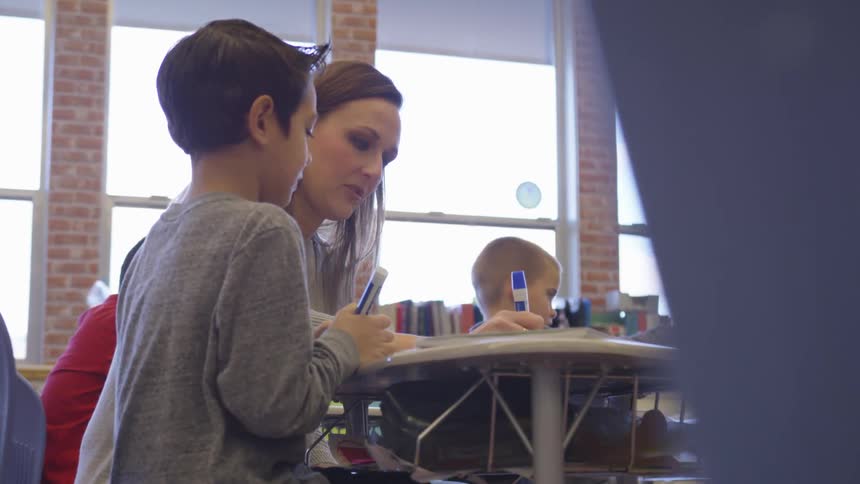 Woman teaching a boy on a classroom