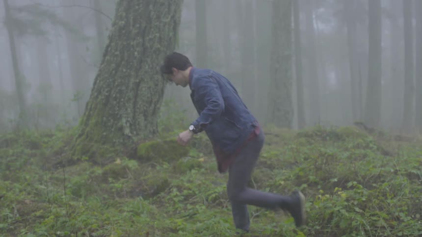 Man throws piece of wood into the forest in the fog