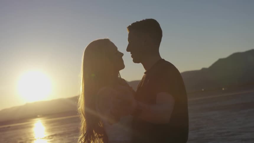 A man pulls a woman in close for a kiss