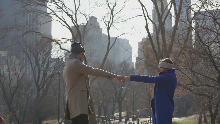 A man and woman holding hands and dancing outside