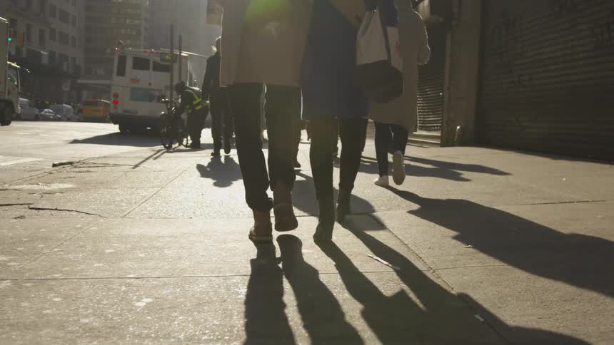 Many people walk on the sidewalk in the city