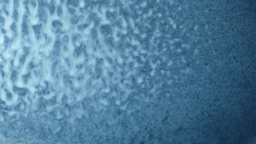 Water is sprayed on to wet paint and it looks like abstract blue art dripping cool mixing white and blue together trippy psychedelic stuff