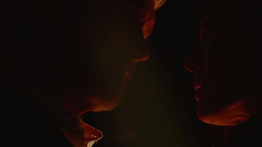A woman and man are standing by each other at night