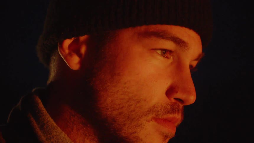 A man is outside looking around at night