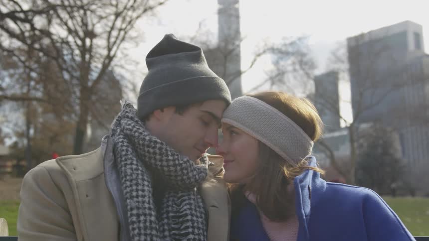 A couple staring at each other in a city park