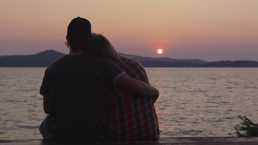 Couple Sitting By The Lake At Dusk