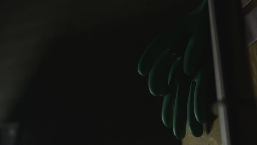 Some rubber glove are hanging in a dark place