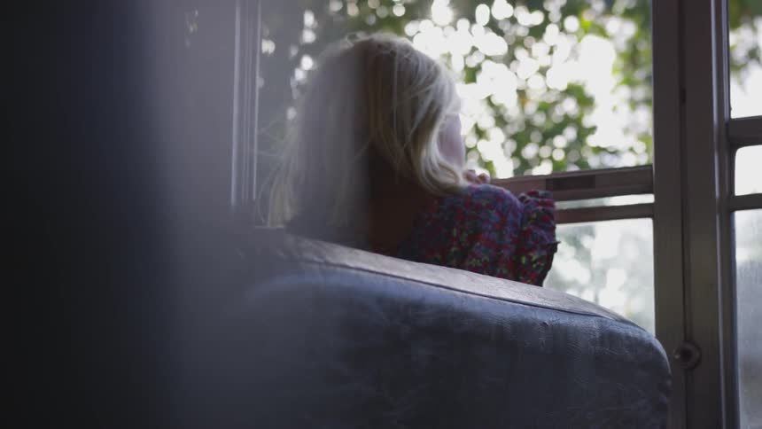 Girl looks out bus open bus window during sunny day