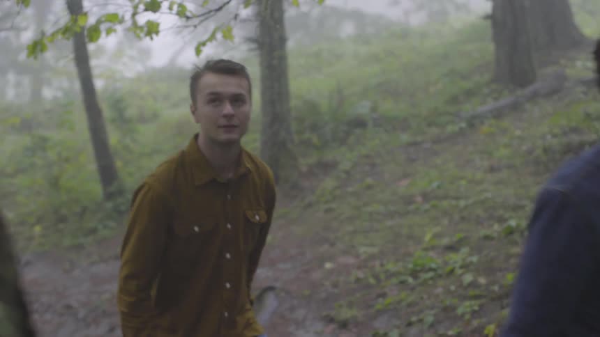 A group of young men walks through the woods