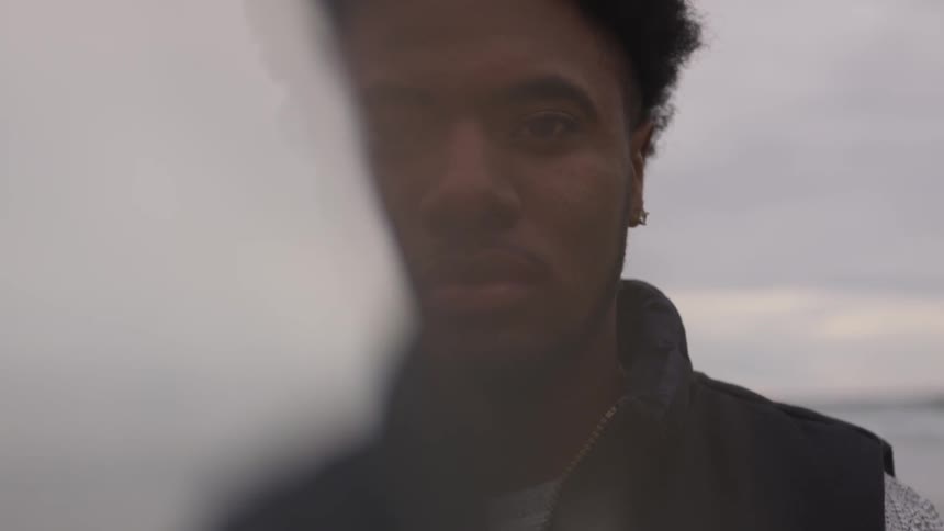 Man stands outside by a body of water