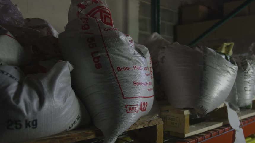 Partially full gray sacks sit on a shelf