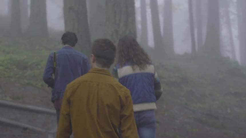 Friends Hiking In Foggy Forest