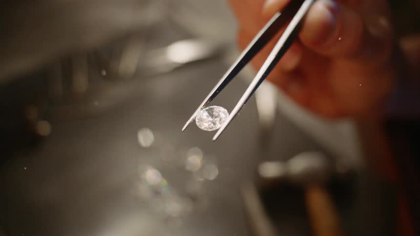 Tweezers holding a diamond gem