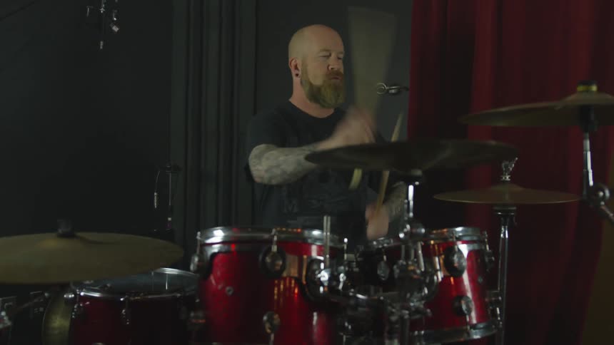 A man playing a drum set in a studio