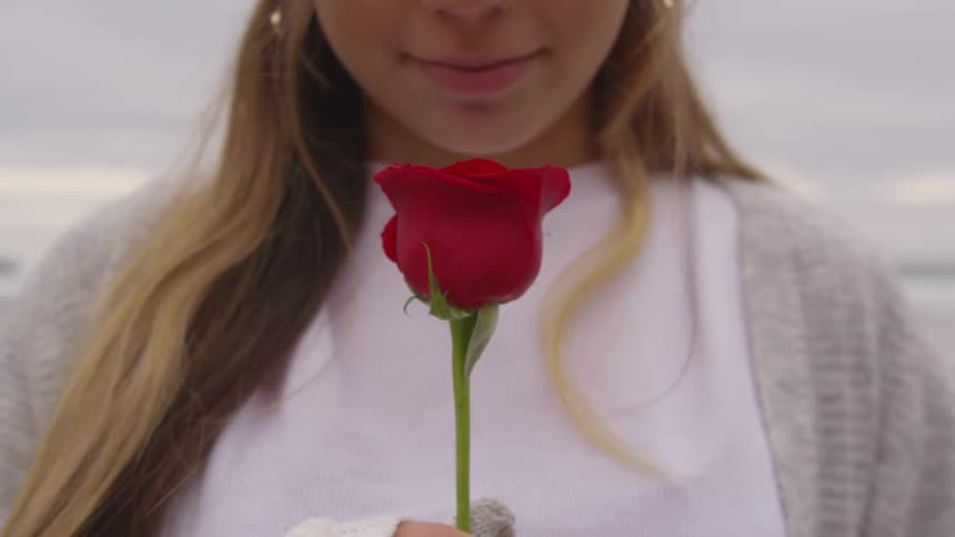 Woman smiling and holding a rose