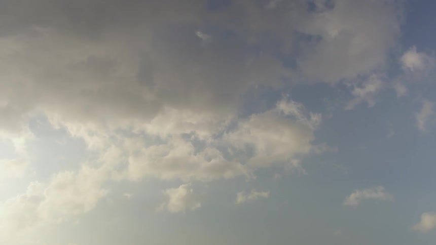 Fluffy white clouds are forming and floating in the blue sky