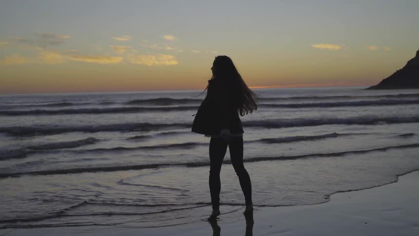 A woman is walking by the beach