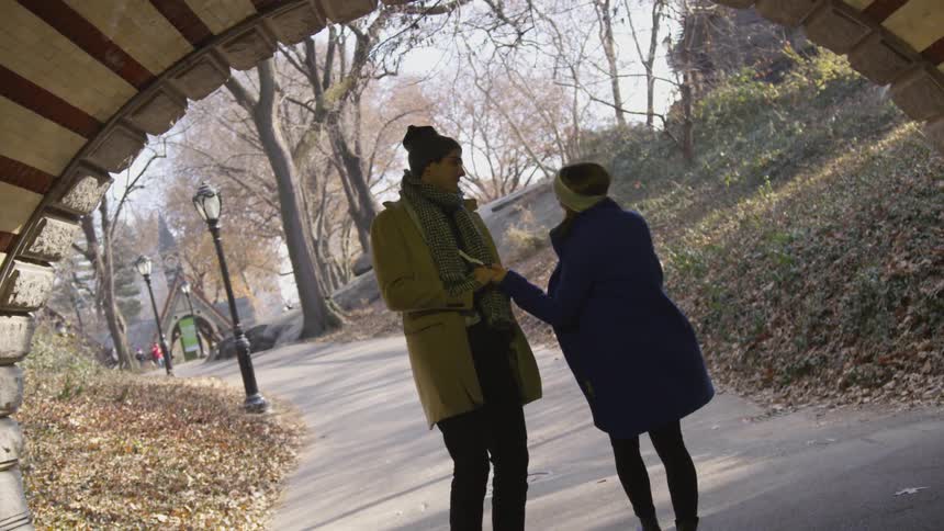 A man and woman walk through a tunnel holding hands