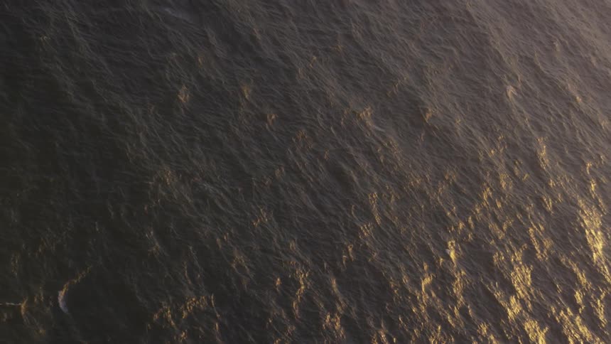 A very large body of water with sun shining on the surface