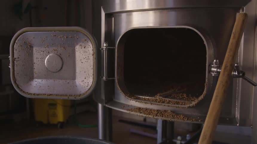 A metallic bin sits with the side door open showing crumbs inside