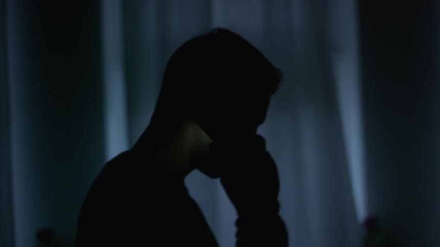 Man talks on his cellphone in the dark