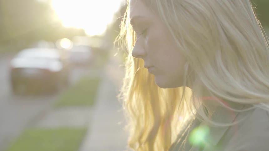 Woman is closing eyes outside