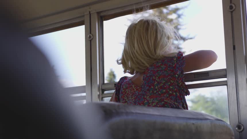 A child leans out of an open window