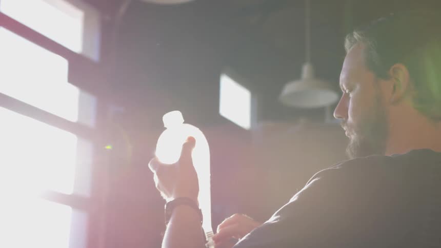 Man reading the label on a bottle in his hand