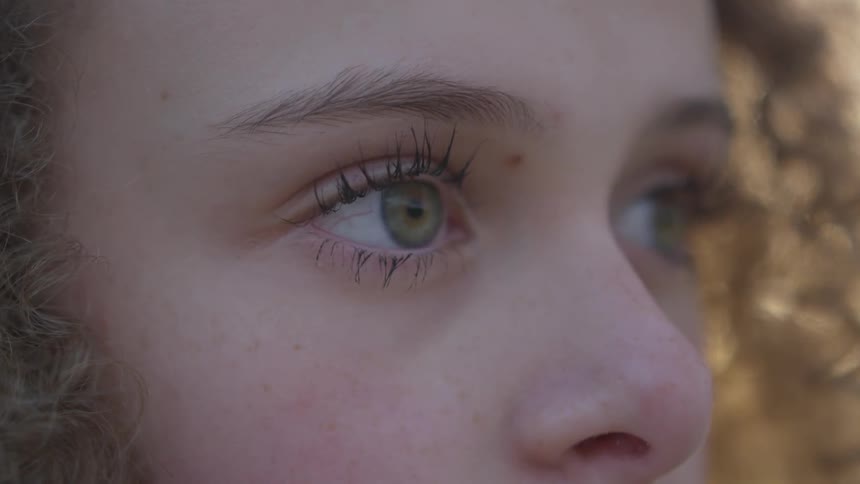 Girl with green eyes looks into the distance