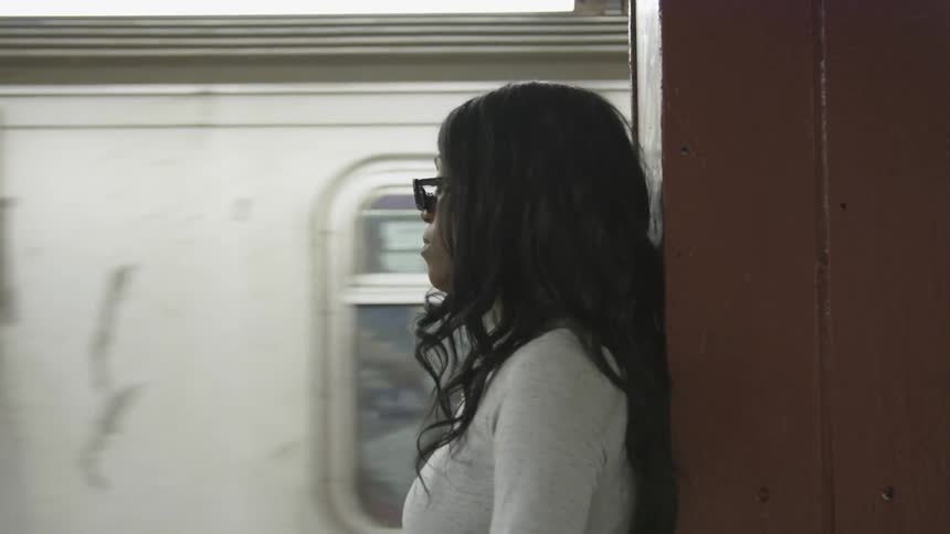 A woman is standing by a subway