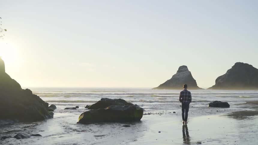 A man is walking by a beach