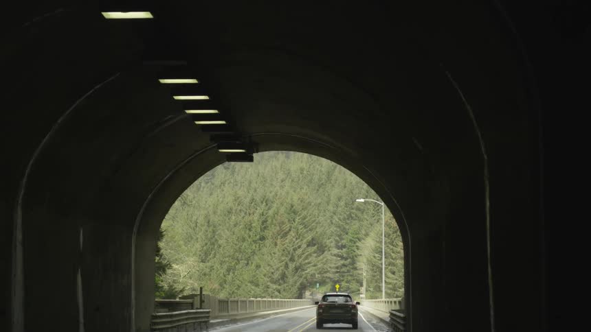 Vehicles drive through an enclosed tunnel