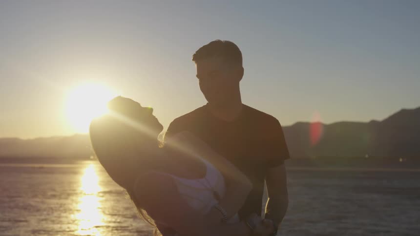 A man and woman dancing in the desert under the sun