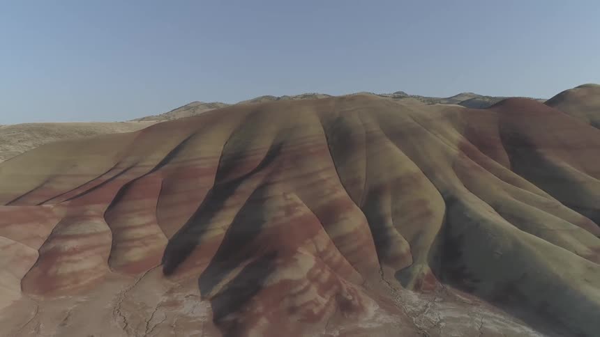 Layered patterns on stone hills under blue sky