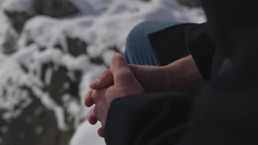 Sitting with hands clasped outside in the snow