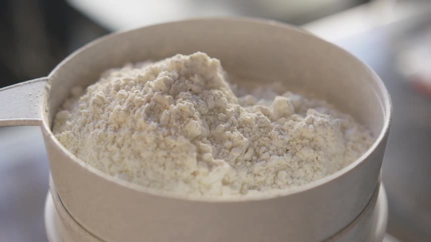 A cup of flour sits on the table