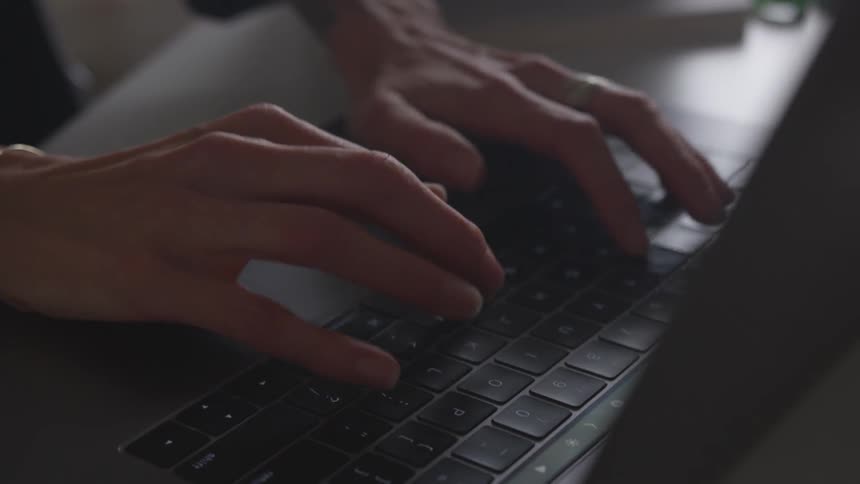 Female hands typing on laptop keyboard
