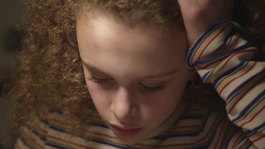 Girl with nose piercing reading something off screen