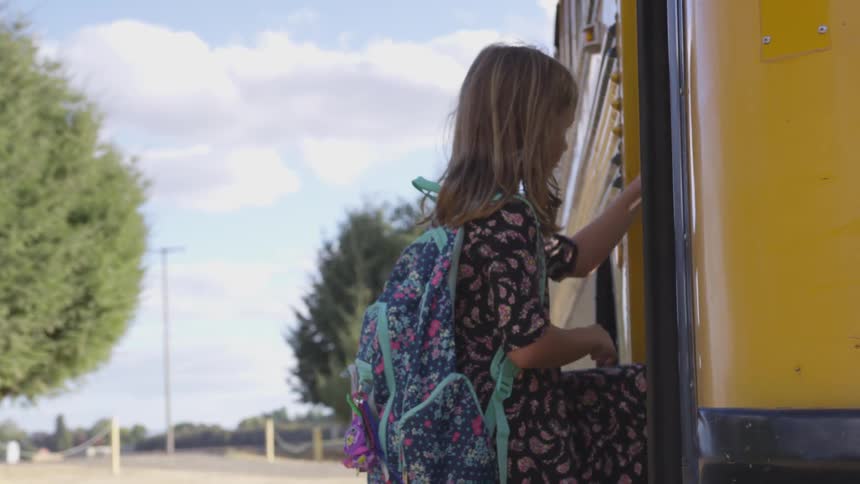 Girl gets on school bus