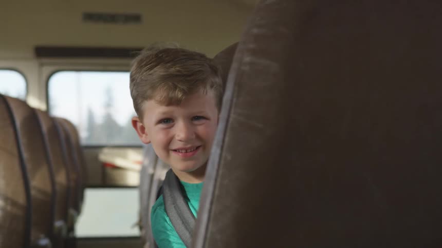 A young boy sits in the school bus