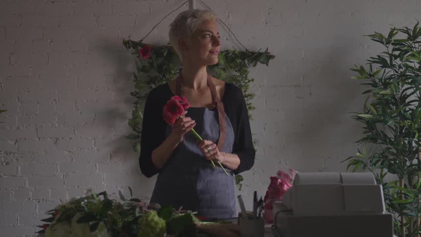 A woman holding flowers in a store