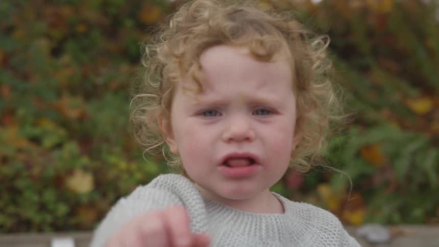 A little girl is jumping and screaming outside