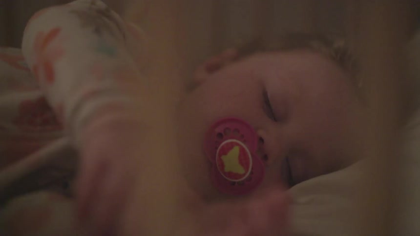 Baby sleeps in crib suckle a pacifier