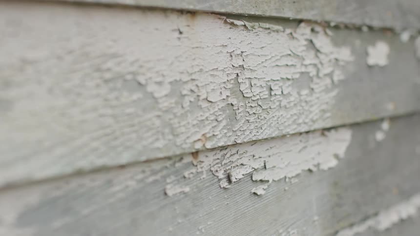 The paint is peeling on the side of the home
