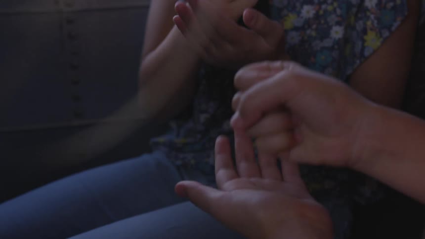 Two kids play rock paper scissors on a bus
