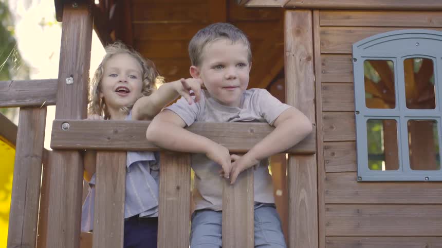 A boy and a girl playing on a treehouse