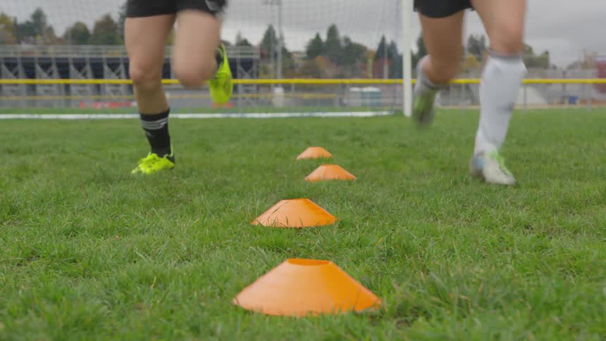 Two people sprint in soccer uniforms