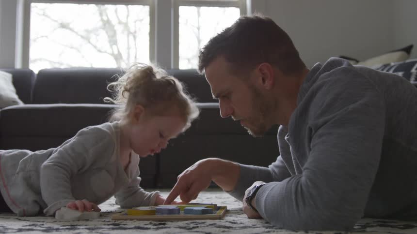 A father and daughter playing in a living room
