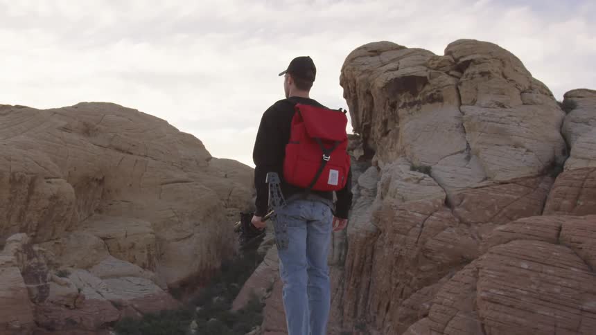 A man with a backpack in a rocky area
