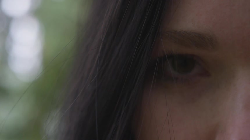 A woman opens her eyes outside